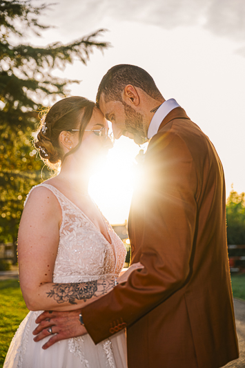 C'est LE portrait romantique par excellence. Marina et Romain sont enlacés, front contre front. Le soleil se couche juste derrière eux, créant un halo lumineux presque magique (le fameux "flare"). On sent une complicité incroyable entre eux