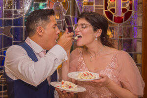 Moment fun et gourmand où Perrine et Jhonatan se font goûter mutuellement leur gâteau de mariage à la fraise lors de la réception au Domaine de la Forêt à Remich