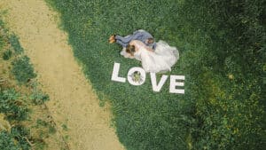 photo de couple aerienne au drone avec les lettres love Mariage Marion & Pierre Roussy le Village